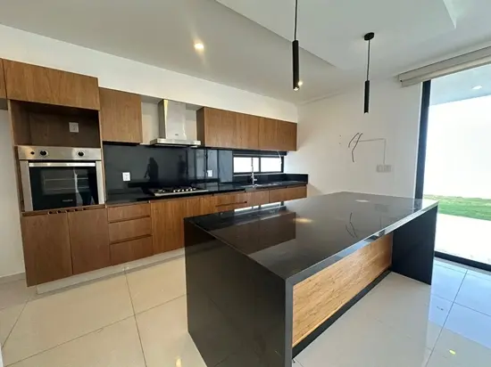 Cocina integral moderna en casa en Queretaro con isla central cubierta de granito y acabados contemporaneos